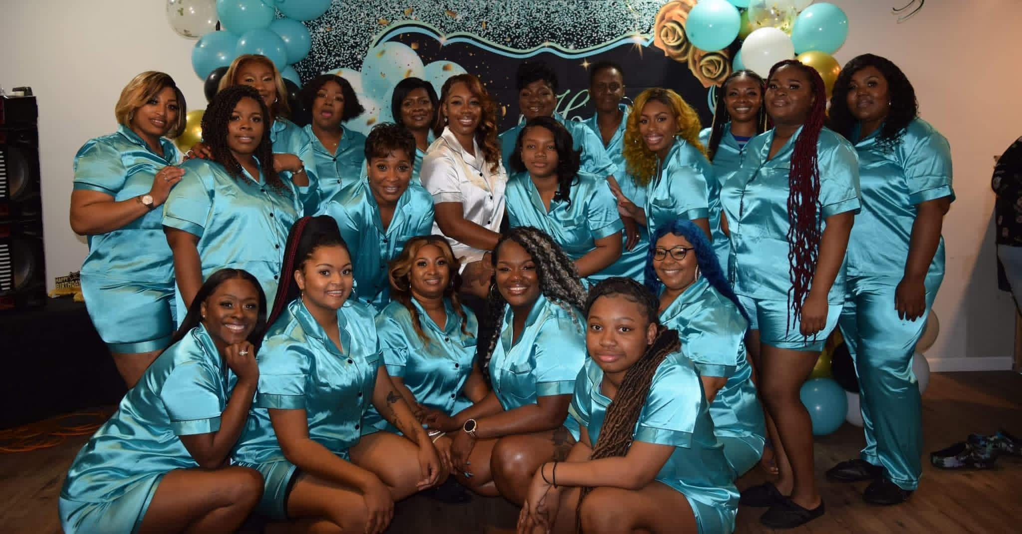 The sisterhood in matching teal satin sets at a celebration.